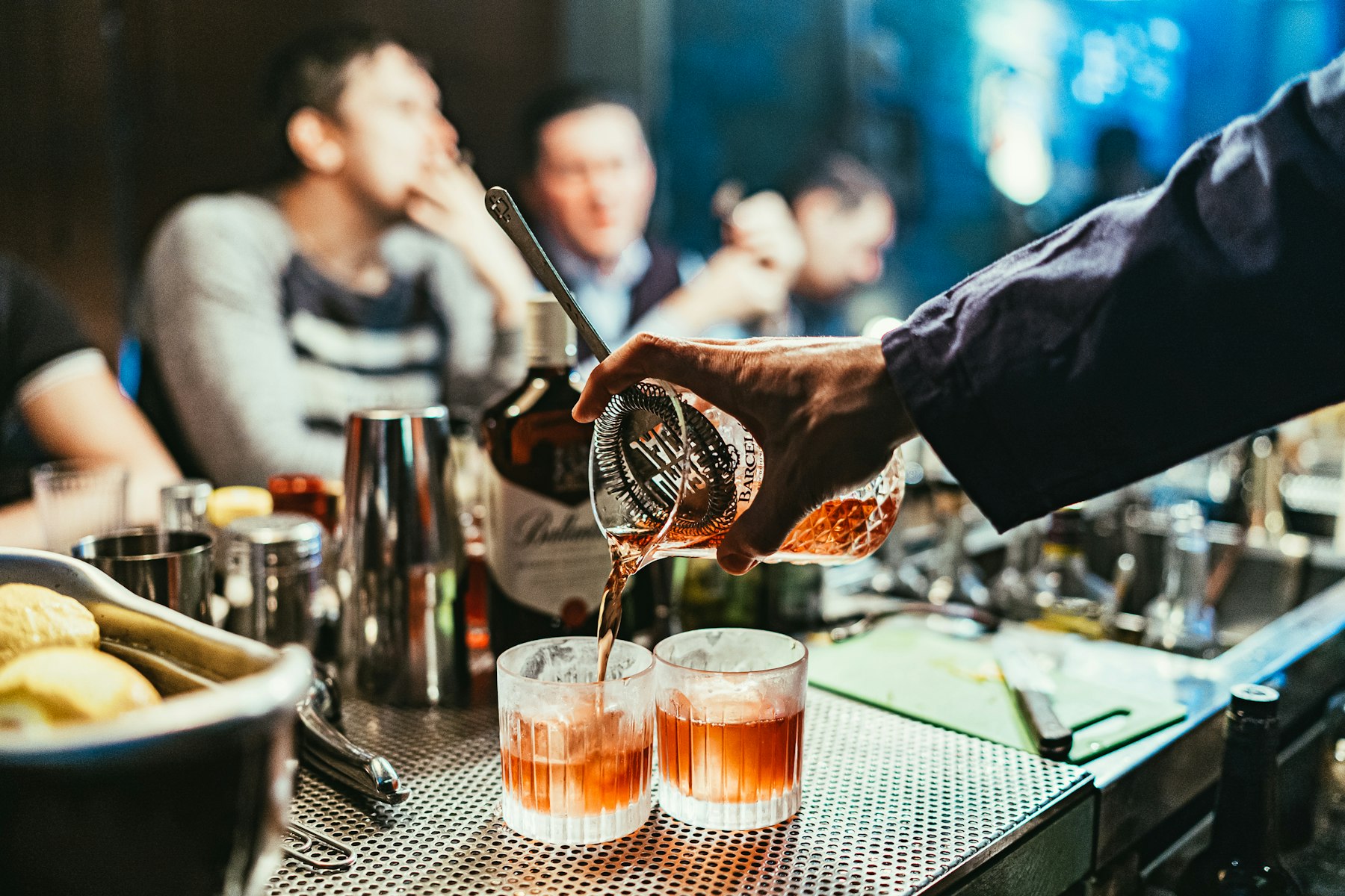 Bartender pouring drinks at a busy bar